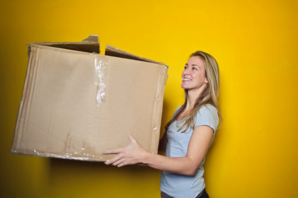 A person holding a box signifying that you won't have to do the heavy lifting with Warrington Removals Company.