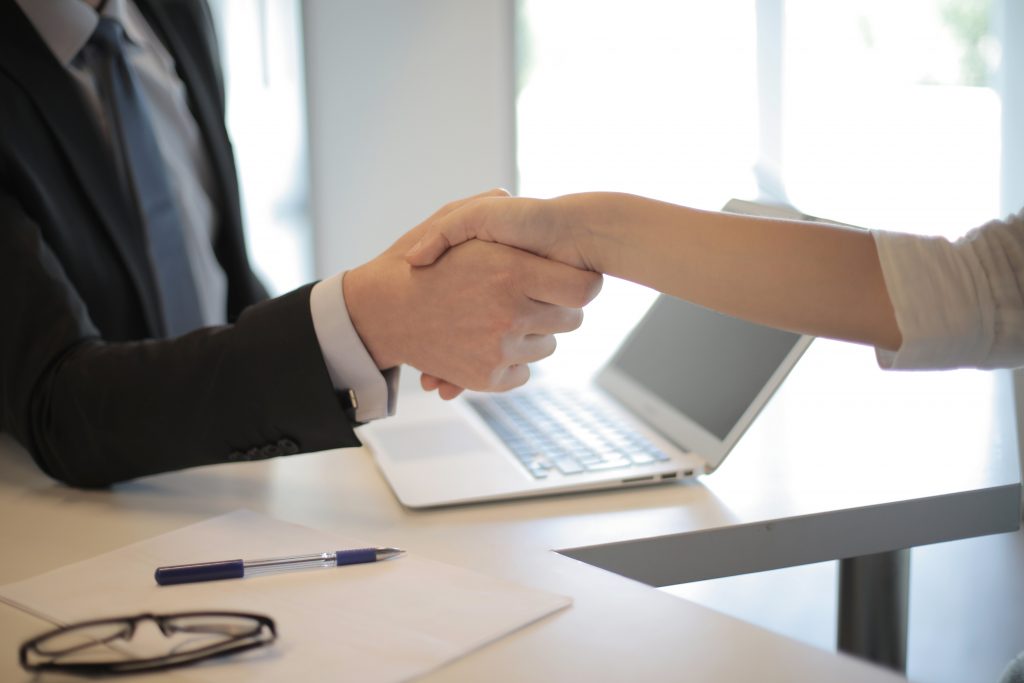 Two people shaking hands. One is hiring the other to help them find a good packing service and materials in Warrington